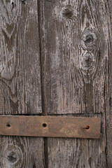 Weathered wooden planks with a rusty metal brace show the beauty of aged textures and the effects of time