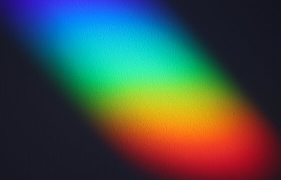 Soft focus rainbow neon grain blur texture wall with prism refraction. Light and shadow smoke abstract gradient rays background.