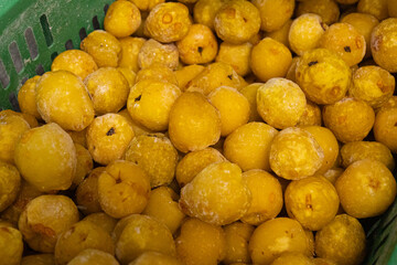 A close-up image showing chopped frozen quinces in various sizes, highlighting their yellow color and icy texture, ideal for culinary use.