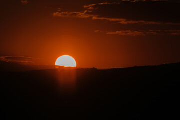 Setting sun ablaze over the horizon painting the sky with vibrant hues A serene moment captured in nature's grand display