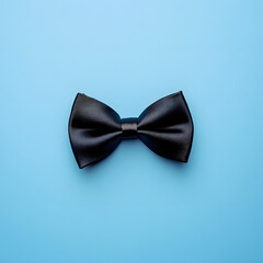 Sleek Black Satin Bowtie Neatly Arranged on a Bright Blue Background.