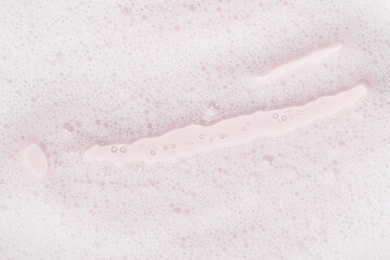 Soft cleansing foam and bubbles on pink background. Ideal for skincare, spa, cosmetic product backgrounds, or wellness-themed visuals.