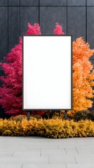 Obraz premium Blank billboard flanked by vibrant autumnal shrubs against a dark wall