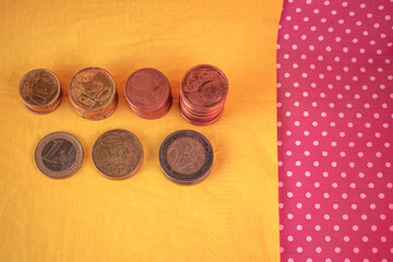 Envision limitless possibilities! This dynamic image features a stack of euro coins against a vibrant yellow backdrop, symbolizing the power of accumulation and bright financial horizons. Ideal for sa