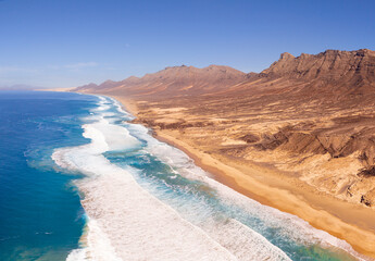 Beautiful high aspect aerial panoramic view of Cofete Beach and the majestic volcanic mountain backdrop in Fuerteventura Canary Islands Spain