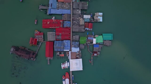 Waterfront homes float beside small boats in Bang Bao, Thailand. Aerial drone video