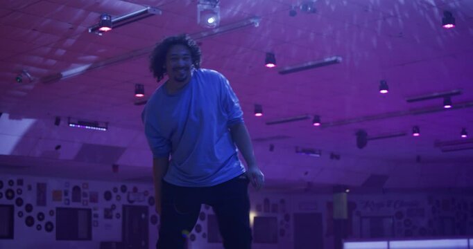 Roller skater in foggy indoor area doing splits and other moves - steady cam low shot