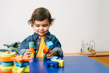 Latina toddler learning with toys in kindergarten - Hispanic heritage culture and back to school concept