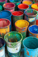Colorful paint containers stacked in a vibrant artist studio during daytime showcasing various hues ready for creative projects