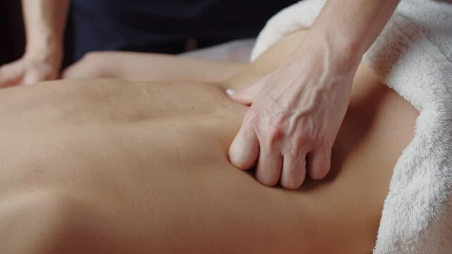 Therapist massaging lower back with fingers