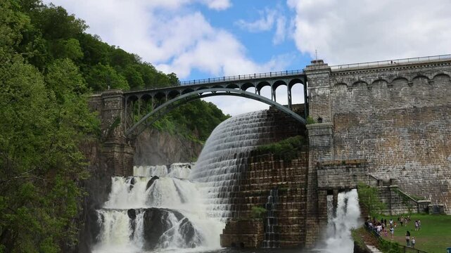 water cascading down waterfall at croton dam (man made and natural drinking water reservoir) westchester new york landmark with old bridge (tourism travel hiking destination) nature landscape