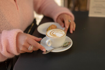 A woman enjoying coffee and a pastry at a caf, perfect for cozy moments
