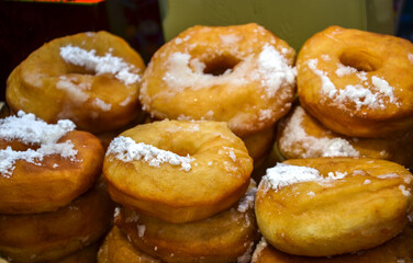 Delicious stack of handmade donuts coated in fine powdered sugar, showcasing freshly baked perfection and sweetness, appealing to pastry lovers
