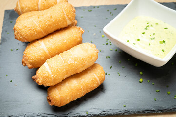 Delicious tequenos served with guasacaca sauce, a traditional venezuelan appetizer