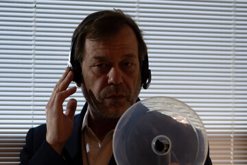 Technical intelligence. A man uses a highly sensitive microphone and headphones for remote...
