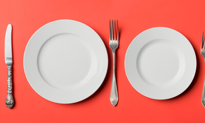 Plate and cutlery isolated on plain background in top view