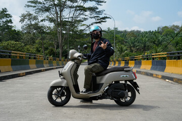 Man Posing on Scooter on a Scenic Bridge in Outdoor Environment