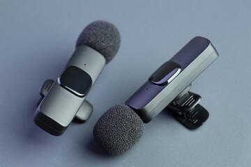 Lavalier microphones on light grey background, closeup