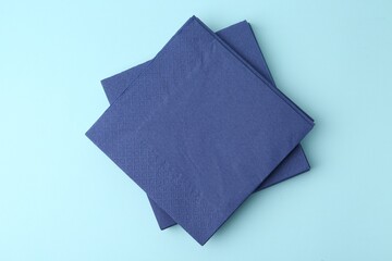 Naklejka premium Stack of disposable paper handkerchiefs on light blue background, top view