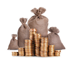 Wealth. Stacked coins and burlap bags isolated on white