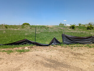 Sagging and damaged stormwater fabric silt fence at a construction site