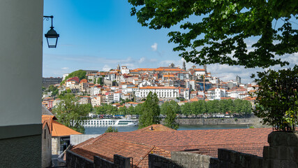 View over rooftops towards the city of Porto, Portugal, on a bright sunny day with blue sky.