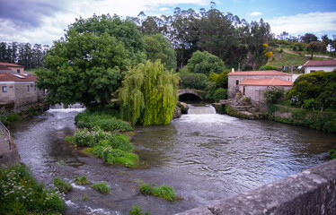 River Este in Touguinho, Portugal. Beautiful Portuguese countryside scene with willow tree and waterfalls
