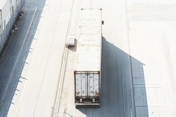 Aerial view of isolated shipping container on a paved surface