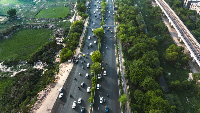 Top down cross traffic highway with cars, trucks aerial. Urban transportation at bridge road at Delhi. Cinematic cityscape of downtown freeway drone shot. Noida Freeway.