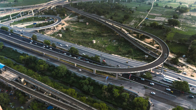 Top down cross traffic highway with cars, trucks aerial. Urban transportation at bridge road at Delhi. Cinematic cityscape of downtown freeway drone shot. Noida Freeway.
