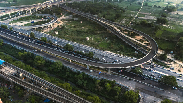 Top down cross traffic highway with cars, trucks aerial. Urban transportation at bridge road at Delhi. Cinematic cityscape of downtown freeway drone shot. Noida Freeway.