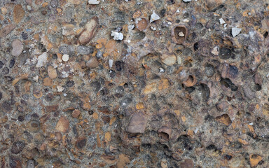 Rough, natural stone texture with earthy tones, perfect for rustic backgrounds and architectural design elements.
