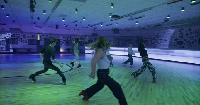 Cinematic, amazing dance by professional roller skaters on smoky, disco, skate floor - steady cam shot