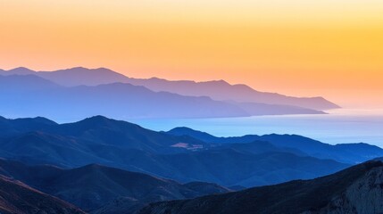 Coastal mountain range at sunset, gradient of blues and golds. Layered peaks meet the ocean