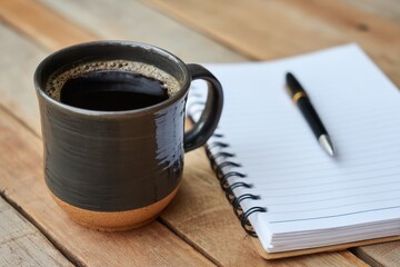 Warm Cup of Coffee Next to a Blank Notepad and Pen on Rustic Wooden Table Creating a Cozy Work Environment for Inspiration and Productivity