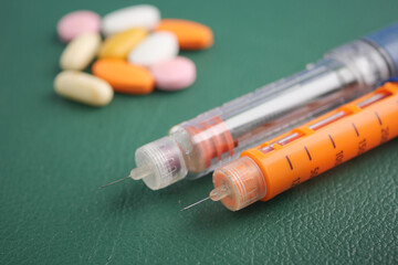 Insulin injection pen for diabetics and medical pills on table 