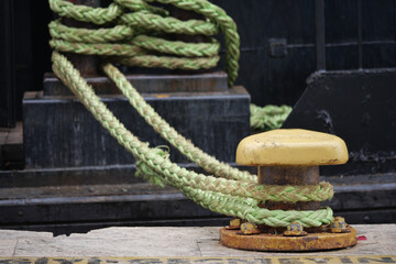 Mooring line secured at harbor dock with yellow cleat