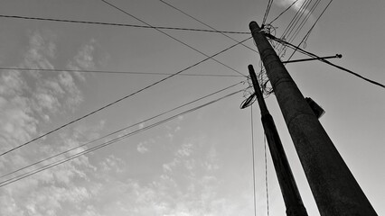 Black and white photo of the power pole with a sky background