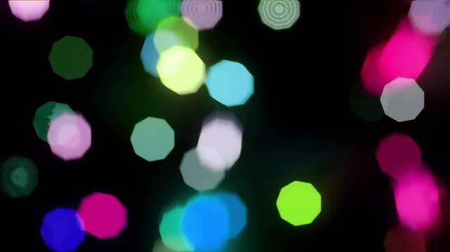 A seamless loop of vibrant abstract bokeh lights featuring multicolored, softly glowing orbs and hexagonal shapes floating on a dark background. Ideal for event videos, music visuals, creative overlay