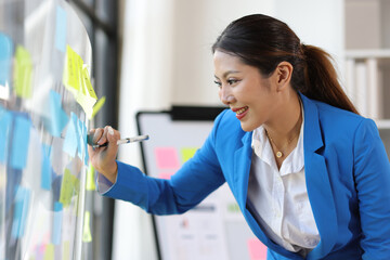 Thoughtful businesswoman thinks creatively and sketches initial business planning with paper...