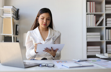 Auditor working in the office. Businesswoman working on financial documents in the office. Female accountant doing accounting work and auditing.