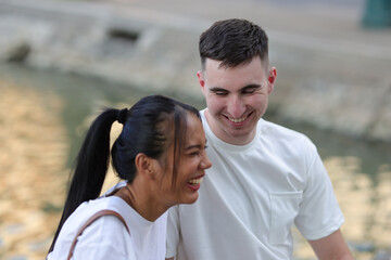 Happy young couple talking and smiling happily. Happy young couple sitting and talking in the park.