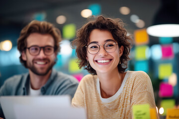 Creative millennial generation colleagues collaborating on new project using sticky notes on glass wall in modern office