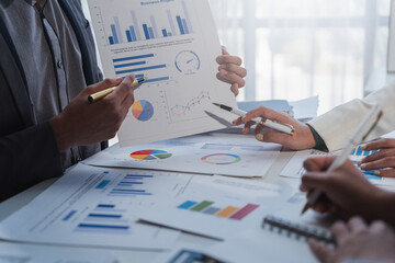 Business team discussing and analyzing financial data using charts and graphs, developing new marketing strategies