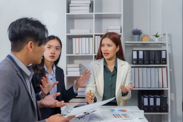 Asian businesspeople arguing during a meeting in the office, expressing tension and frustration...
