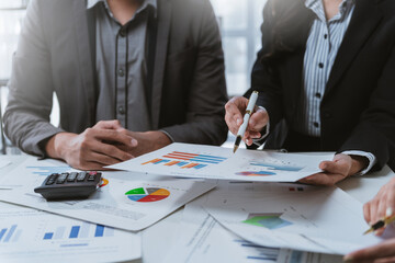 Business team collaborating and analyzing financial data while discussing strategies for company...