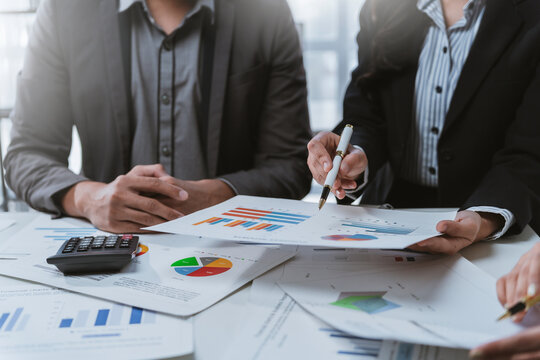 Business team collaborating and analyzing financial data while discussing strategies for company growth during a productive meeting