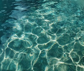 Obraz premium Teal water shimmers with sunlight, creating an intricate pattern of light and shadow on the surface