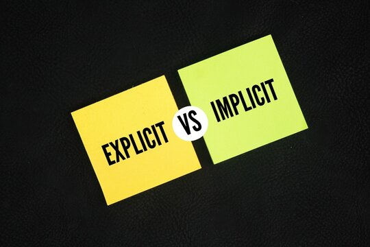 Colored paper with the words explicit vs implicit. motivational words positive and negative