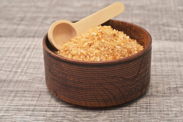 Brown sugar in woonden bowl with spoon background. Sugar type  are fructose, glucose, lactose. Over consumption can be weight gain, type 2 iabetes and heart disese.